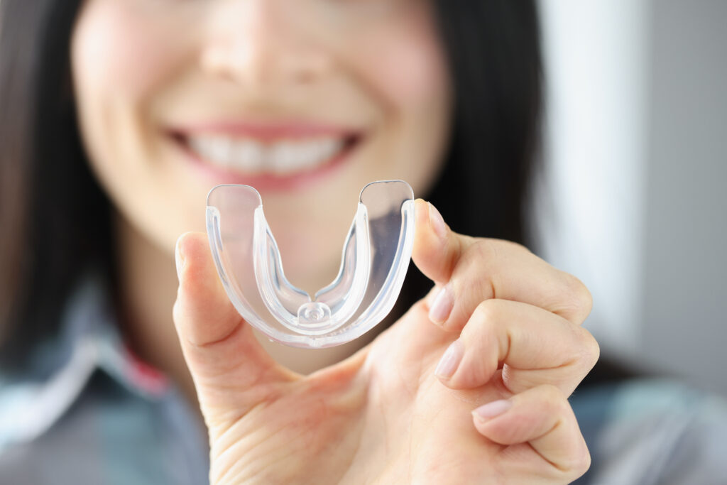 Smiling,Woman,Holds,Transparent,Plastic,Mouth,Guard,In,Her,Hand